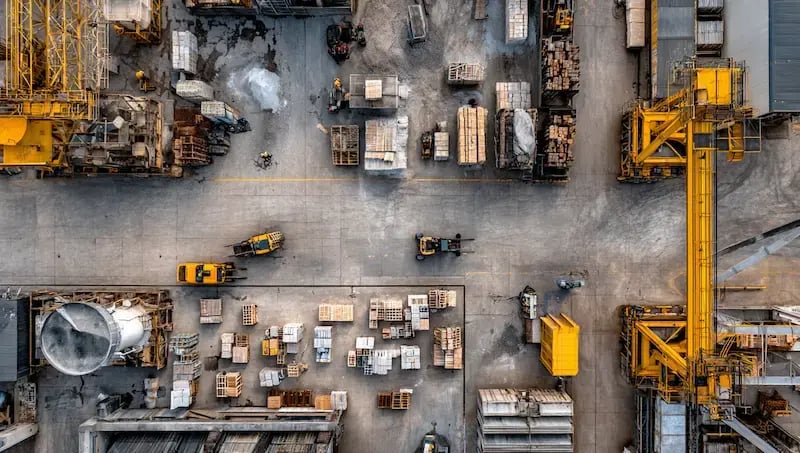 bizzywebai_Aerial_view_of_an_industrial_warehouse_with_cranes_a_ede31b5b-74c8-47ae-80b5-6ac9cf997689 1