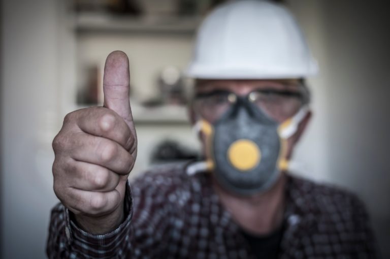 a man in protective gear giving a thumbs-up